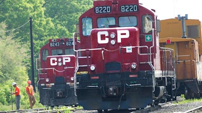Surveyors work next to Canadian Pacific Rail trains which are parked on the train tracks in Toronto on May 23, 2012.