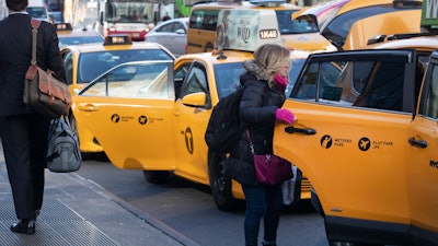 A passenger gets into a taxi, New York, Jan. 29, 2020.