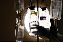 A nurse checks on IV fluids while talking to a COVID-19 patient at Providence Holy Cross Medical Center, Los Angeles, Dec. 13, 2021.
