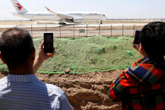 Residents watch as a China Eastern passenger jet prepares to take off on a test flight from the new Beijing Daxing International Airport on Monday, May 13, 2019. State media are reporting a Chinese airliner from China Eastern with 133 people on board crashed in the southern province of Guangxi on Monday, sparking a mountainside fire.