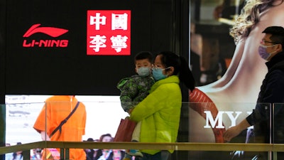 Visitors to a mall walk past signs of Chinese sports brand Li Ning on Wednesday, March 16, 2022, in Beijing. The U.S. customs agency says it is holding imported goods from Li Ning after an investigation indicated they were made by North Korean labor. U.S. law prohibits imports of goods made in North Korea or by North Korean citizens without proof they weren’t made by forced labor, according to a notice from the U.S. Customs and Border Protection in Washington.