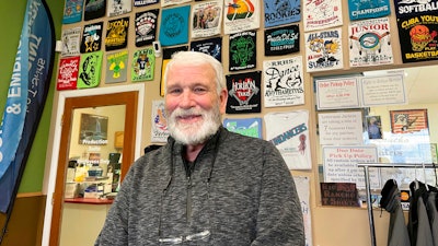 Wayne Holly, the owner of Rio Rancho T-Shirts, poses for a portrait at the family-owned shop in Rio Rancho, N.M., Monday, March 21, 2022. Holly said the small business he and his wife have operated for more than 20 years is feeling the pinch of inflation and that tax rebates offered by state governments won't be enough to combat rising prices or ongoing economic fallout from the coronavirus pandemic.