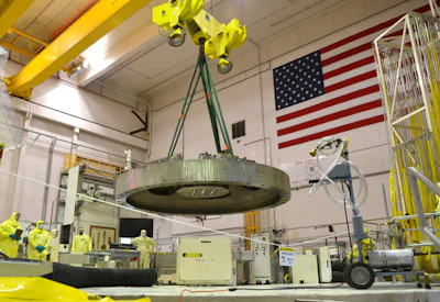 Operations and maintenance team members stand back as the 32-ton top head of the Advanced Test Reactor is lowered back into place during an overhaul of INL’s flagship test reactor.