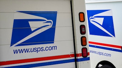 In this Aug. 18, 2020, photo, mail delivery vehicles are parked outside a post office in Boys Town, Neb. Democrats on the House Oversight Committee are seeking an investigation into a U.S. Postal Service plan to replace its aging mail trucks with mostly gasoline-powered vehicles.