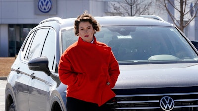 Kendall Heiman stands with the loner car she has driven for the past two months, Wednesday, March 9, 2022, in Lawrence, Kan., while a dealership works to repair her Volkswagen 2021 Atlas Cross Sport after the car slammed on the brakes for no reason on Jan. 5. Heiman and a dozen other Cross Sport owners have filed complaints about the issues with the U.S. National Highway Traffic Safety Administration.