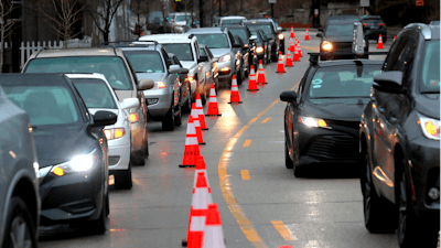 Cars line up early morning along Green Bay Road waiting to receive free gas donated by Willie Wilson at the Mobil Gas Station on Thursday, March 24, 2022, in Evanston, Ill.