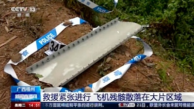 Some of the personal effects of 132 lives presumed lost were lined up by rescue workers scouring a remote mountainside Tuesday for the wreckage of a China Eastern plane that one day earlier inexplicably fell from the sky and burst into a huge fireball.