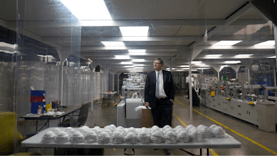 Jim Schmersahl, owner of Halcyon Shades, poses in a 'clean room' used in making N-95 masks at the company's production facility Friday, March 18, 2022, in University City, Mo. Halcyon is small company that normally makes window shades, but when the pandemic hit, its sales plummeted. Halcyon applied for the state grants to make PPE as a way to try to keep its employees at work and keep the company afloat.