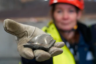 Susanne Rostmark, research leader, LKAB, holds a piece of hot briquetted iron ore made using the HYBRIT process nearby the venture’s pilot plant in Lulea, Sweden, Feb. 17, 2022.
