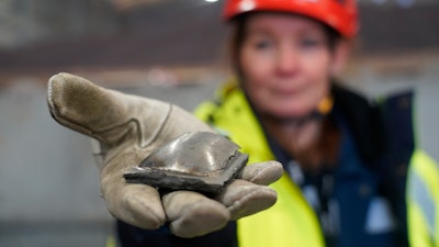 Susanne Rostmark, research leader, LKAB, holds a piece of hot briquetted iron ore made using the HYBRIT process nearby the venture’s pilot plant in Lulea, Sweden, Feb. 17, 2022.