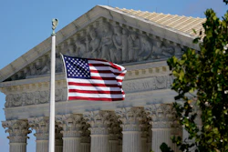 An American flag blows in the wind in front of the Supreme Court building on Capitol Hill in Washington, Nov. 2, 2020.