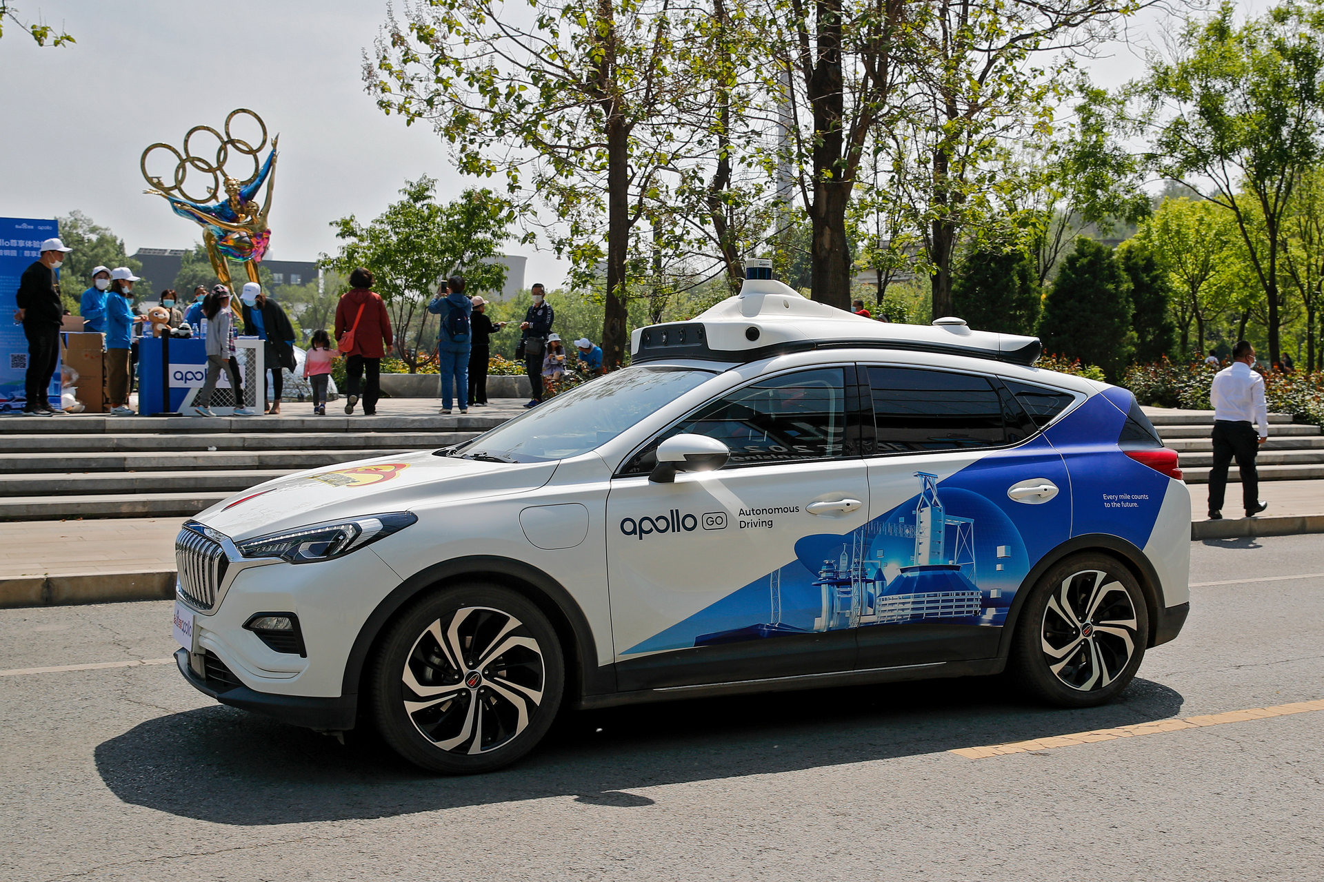 A Baidu Apollo Robotaxi passes its customer service counter setup at the Shougang Park in Beijing, Sunday, May 2, 2021. China has granted Chinese internet services company Baidu and a rival autonomous car company, Pony.ai, permits to provide driverless ride-hailing services to the public in Beijing, a significant regulatory step in the country's pursuit of driverless technology.