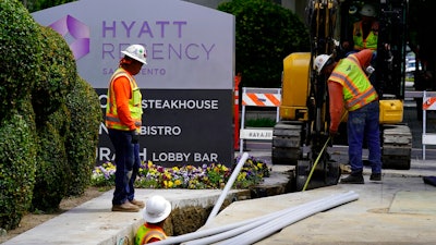 Workers install piping for underground electrical lines in Sacramento, Calif., Wednesday, April 20, 2022. California workplace regulators are poised to extend mandatory pay for workers affected by the coronavirus through the end of 2022, more than two months after state lawmakers restored similar benefits through September.