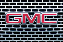 The GMC logo is displayed on the grill of a truck at a GMC dealership in Warminster, Pa., Tuesday, April 26, 2022. General Motors’ net income declined in the first quarter of 2022, as the automaker sold fewer cars and trucks worldwide, although higher prices helped boost revenue, especially in North America.