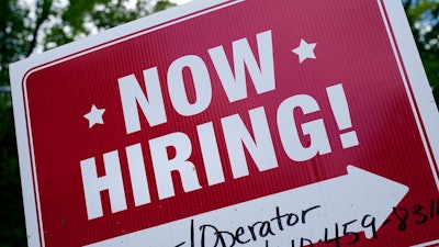 A 'now hiring' sign is posted in Garnet Valley, Pa., Monday, May 10, 2021. Applications for unemployment benefits inched down last week, Thursday, April 21, 2022, as the total number of Americans collecting aid fell to its lowest level in more than 50 years.