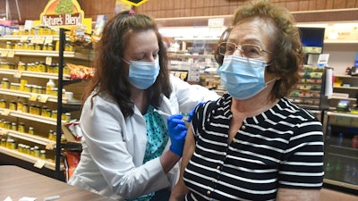 Pharmacist Karen Flynn gives a second Moderna booster shot to her mother Joann Pangonis, of New Boston, Pa., at Morris Drug in Mahanoy City, Pa., on Friday, April 1, 2022. An extra-contagious version of the omicron coronavirus variant has taken over the world. The variant scientists call BA.2 is now dominant in at least 68 countries, including the U.S. The World Health Organization says it makes up about 94% of sequenced omicron cases submitted in the most recent week to an international database.