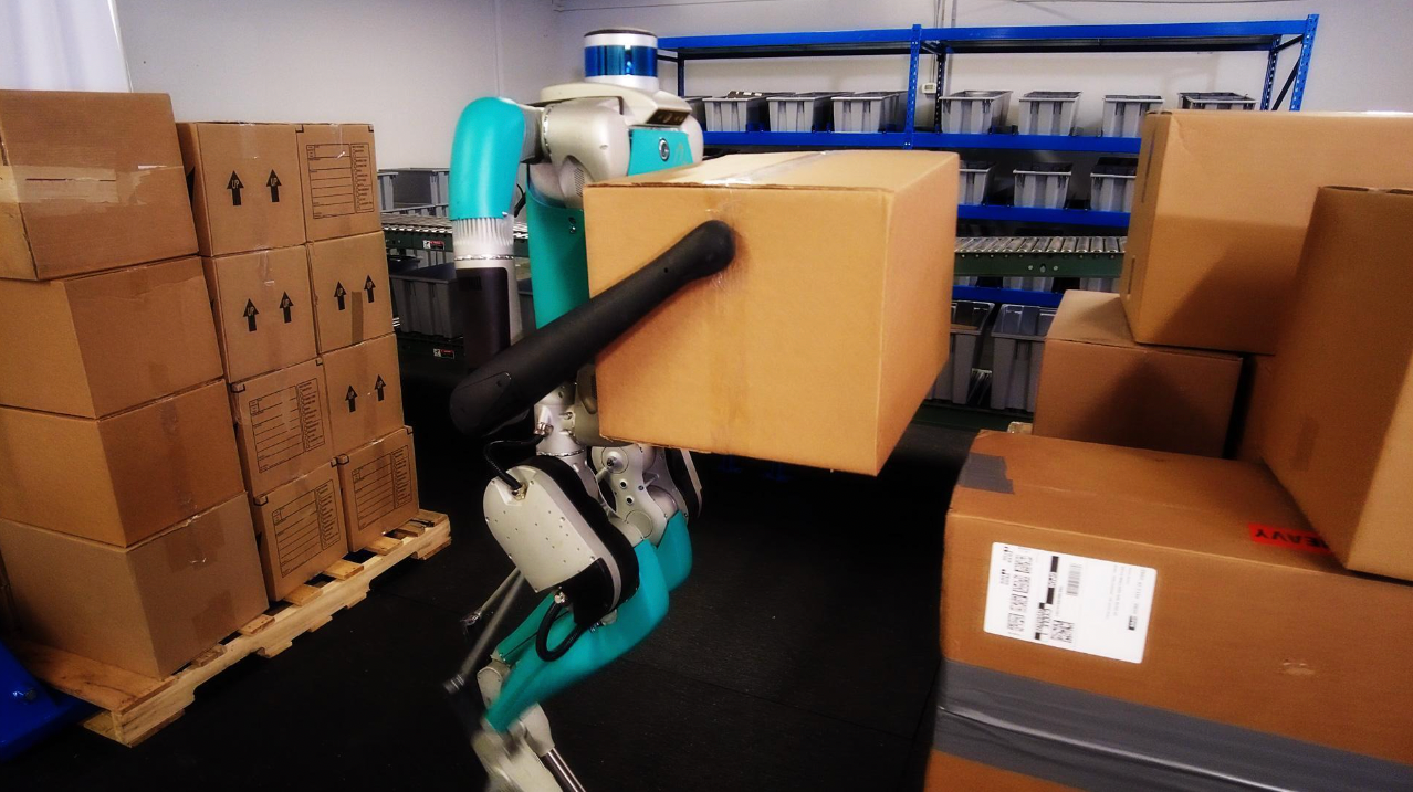 Digit, Agility Robotics' robot, moving packages full of sorted goods inside a warehouse.