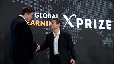 Tesla CEO Elon Musk, left, shakes hands with XPRIZE founder and Executive Chairman Peter Diamandis during an XPRIZE presentation event in Los Angeles, May 15, 2019. From algae farming to producing a sort of artificial limestone, ideas for reducing greenhouse gas in the atmosphere are getting a funding boost from famed entrepreneur Musk. The Tesla electric vehicle and SpaceX rocket company developer is bankrolling a $100 million XPRIZE Carbon Removal competition for the most promising ways to reduce atmospheric carbon dioxide by grabbing the gas right out of the air.