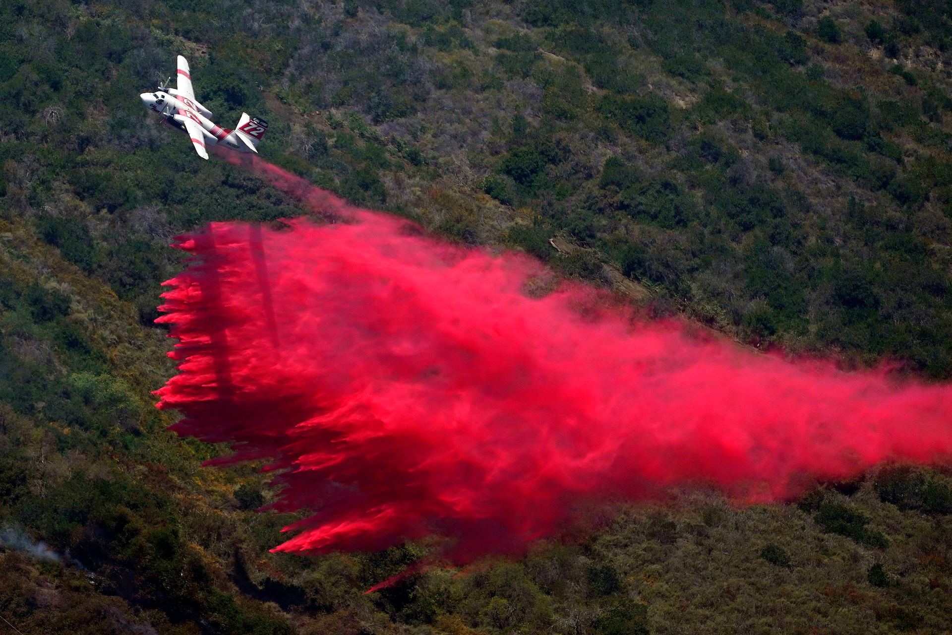 A plane drops fire retardant onto the Coastal Fire Thursday, May 12, 2022, in Laguna Niguel, Calif.