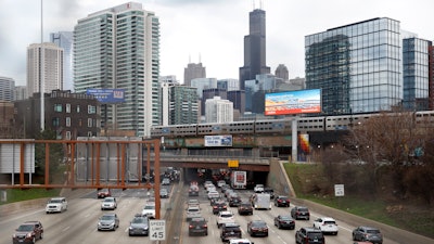 Traffic flows along Interstate 90 highway as a Metra suburban commuter train moves along an elevated track in Chicago on March 31, 2021. With upcoming data showing traffic deaths soaring, the Biden administration is steering $5 billion in federal aid to cities and localities to address the growing crisis by slowing down cars, carving out bike paths and wider sidewalks, and nudging commuters to public transit.