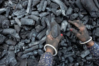 A woman works at a coal depot in Ahmedabad, India, Monday, May 2, 2022. An unusually early and brutal heat wave is scorching parts of India, where acute power shortages are affecting millions as demand for electricity surges to record levels. Supplies of coal at many thermal power plants are running perilously low, spawning daily power outages in several states. The shortages are sparking scrutiny of India’s long reliance on coal, which produces 70% of the country’s electricity.