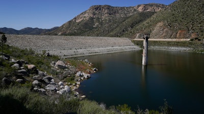 The dam at El Capitan Reservoir is seen Friday, April 8, 2022, in Lakeside, Calif. Constructed four generations ago, the massive rock and clay dam is capable of storing over 36 billion gallons of water — enough to supply every resident in San Diego for most of a year. Today, it's three-quarters empty — intentionally kept low because of concerns it could fail under the strain of too much water.