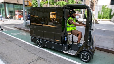 UPS worker Dyghton Anderson peddles an eQuad electric bike in a bicycle lane while delivering packages, in New York, Tuesday, June 14, 2022. Delivery giant UPS is going back to the future in its latest way to get packages to the doors of its millions of customers. The company is considering launching a fleet of pedal- and battery-powered cargo cycles for deliveries in some of the country's most congested cities.