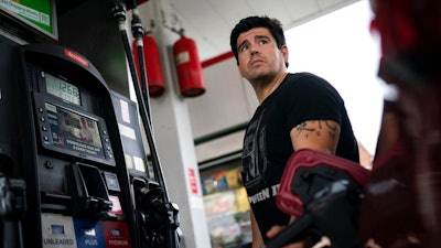 Wallace Reid fuels his vehicle he drives to make a living using ride-share apps, Wednesday, June 22, 2022, in the Queens borough of New York. Millions of Americans who rely on their cars for work are changing their habits, signing up for carpools or even ditching their cars for bicycles as gas prices recently hit $5 per gallon for the first time ever.