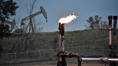 A flare to burn methane from oil production is seen on a well pad near Watford City, N.D., on Aug. 26, 2021. The U.S. government this week is holding its first onshore oil and gas sales from public lands since President Joe Biden took office.