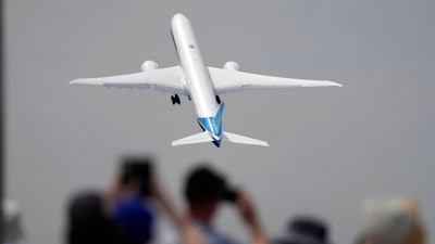 A Boing 777X plane takes off at the Farnborough Air Show fair in Farnborough, England, Monday, July 18, 2022. Some 1200 exhibitors from around the world will show their newest developments in Future Flight, Space, Defence, Innovation, Sustainability and Workforce from July 18 until July 22, 2022.