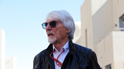Former Formula One boss Bernie Ecclestone walks in the paddock during the first free practice at the Yas Marina racetrack in Abu Dhabi, United Arab Emirates, Friday Nov. 23, 2018. British prosecutors say former Formula One boss Bernie Ecclestone will be charged with fraud by false representation following a government investigation into his overseas assets.