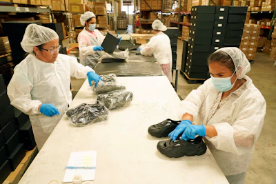 Gabriella Villanueva, clockwise from left, Marina Medina, Gladys Sibrian and Margarita Enriquez assemble Plastic Soul shoe packages at the Doc Johnson factory and corporate offices, Thursday, Aug. 18, 2022, in Los Angeles. Streetwear label Rose in Good Faith and sex toy company Doc Johnson have partnered to create a shoe derived in part from unused or defective sex toys.