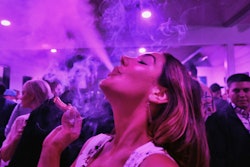 A guest takes a puff from a marijuana cigarette at the Sensi Magazine party celebrating the 420 holiday in the Bel Air section of Los Angeles on April 20, 2019.