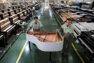 In this photo released by Xinhua News Agency, workers transfer a half-assembled piano at a production factory of Parsons Music Corporation in Yichang, central China's Hubei Province, on Nov. 23, 2021. Chinese manufacturing’s recovery from anti-virus shutdowns faltered in July as activity sank, a survey showed Sunday, July 31, 2022, adding to pressure on the struggling economy in a politically sensitive year when President Xi Jinping is expected to try to extend his time in power.