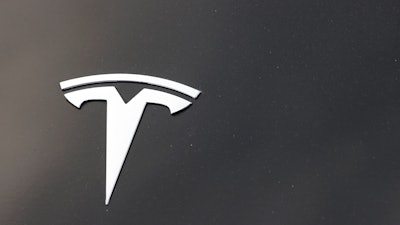 The Tesla company logo is seen on the hood of an unsold vehicle at a dealership, Sunday, Aug. 9, 2020, in Littleton, Colo. Tesla is recalling nearly 1.1 million vehicles in the U.S. because the windows can pinch a person’s fingers when being rolled up.