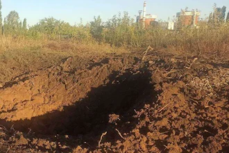 In this photo provided by the South Ukraine nuclear power plant, a crater left by a Russian rocket is seen 300 meter from the South Ukraine nuclear power plant, in the background, close to Yuzhnoukrainsk, Mykolayiv region, Ukraine, Monday, Sept. 19, 2022.