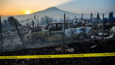 The sun rises over Mt. Shasta and homes destroyed by the Mill Fire on Saturday, Sept. 3, 2022, in Weed, Calif.