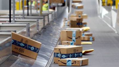 Packages move along a conveyor at an Amazon warehouse, Goodyear, Ariz., Dec. 17, 2019.
