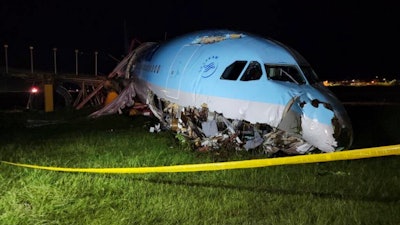 In this handout photo provided by the Civil Aviation Authority of the Philippines, a damaged portion of the Korean Air Lines Co. plane lies after it overshot the runway at the Mactan Cebu International Airport in Cebu, central Philippines, on Monday, Oct. 24, 2022. A Korean Air Lines Co. plane carrying 173 passengers and crew members overshot a runway while landing in bad weather in the central Philippines late Sunday and authorities said all those on board were safe. The airport is temporarily closed due to the stalled aircraft.