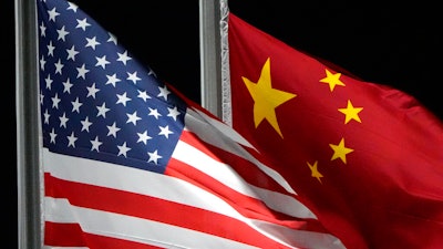The American and Chinese flags wave at Genting Snow Park ahead of the 2022 Winter Olympics, Feb. 2, 2022, in Zhangjiakou, China. The Commerce Department is tightening export controls to limit China’s ability to get advanced computing chips, develop and maintain supercomputers, and make advanced semiconductors.
