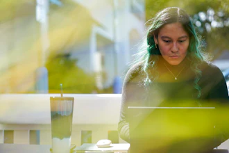 Daniella Malave works on her laptop at a coffee shop in Sea Girt, N.J., Thursday, Sept. 29, 2022. While working full time for Chipotle, Malave completed two years of community college with annual stipends of $5,250 from the restaurant chain. After that, she enrolled in the company’s free online college program, through which she earned a bachelor’s degree in business management from Wilmington University in 2020.