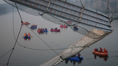 Rescuers on boats search in the Machchu river next to a cable suspension bridge that collapsed in Morbi town of western state Gujarat, India, Monday, Oct. 31, 2022.