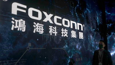 A man walks past the Foxconn logo during the 2022 Hon Hai Tech Day (HHTD 22) at the Nangang Exhibition Center in Taipei, Taiwan, Tuesday, Oct. 18, 2022.