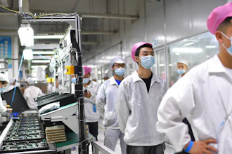 Workers line up to get tested for COVID-19 at the Foxconn factory in Wuhan in central China's Hubei province on Aug. 5, 2021. Employees at the world's biggest Apple iPhone factory have been beaten and detained in protests over contract disputes amid anti-virus controls, according to employees and videos posted on social media Wednesday, Nov. 23, 2022. Videos on Chinese social media that said they were filmed at the factory in the central city of Zhengzhou showed thousands of people in masks facing rows of police in white protective suits with plastic riot shields.