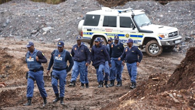 South African police investigate at the scene where more than 20 bodies, suspected of being illegal miners, were found near an active mine in Krugersdorp, South Africa, Thursday, Nov. 3, 2022. Police suspect that the bodies were moved to where they were found at a privately-owned mine. The grim discovery is the latest in a series of incidents related to illegal mining in the Krugersdorp area.