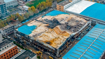 In this aerial photo, a building at the center of a deadly fire is seen in Anyang in central China's Henan Province, Tuesday, Nov. 22, 2022. Investigators said that sparks from welding work appears to have been the cause of a fire that killed several dozen people at a company dealing in chemicals and other industrial goods in central China's Henan province.