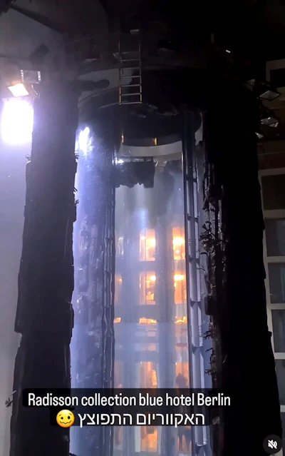 Following the burst of a huge aquarium, the atrium of a hotel is devastated in Berlin Germany, Friday, Dec. 16, 2022. German police say a huge aquarium in the center of Berlin has burst, causing a wave of devastation in and around the Sea Life tourist attraction. The words in Hebrew reads: 'The Aquarium exploded'.