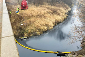 A remediation company deploys a boom on the surface of an oil spill after a Keystone pipeline ruptured at Mill Creek in Washington County, Kansas, on Thursday, Dec. 8, 2022. Vacuum trucks, booms and an emergency dam were constructed on the creek to intercept the spill.