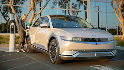 This photo provided by Hyundai shows a woman charging a 2022 Hyundai Ioniq 5 at a charging station.