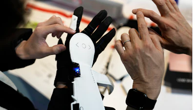 An attendee looks at Haptic Metaverse Gloves by AI Silk during the CES tech show Thursday, Jan. 5, 2023, in Las Vegas.